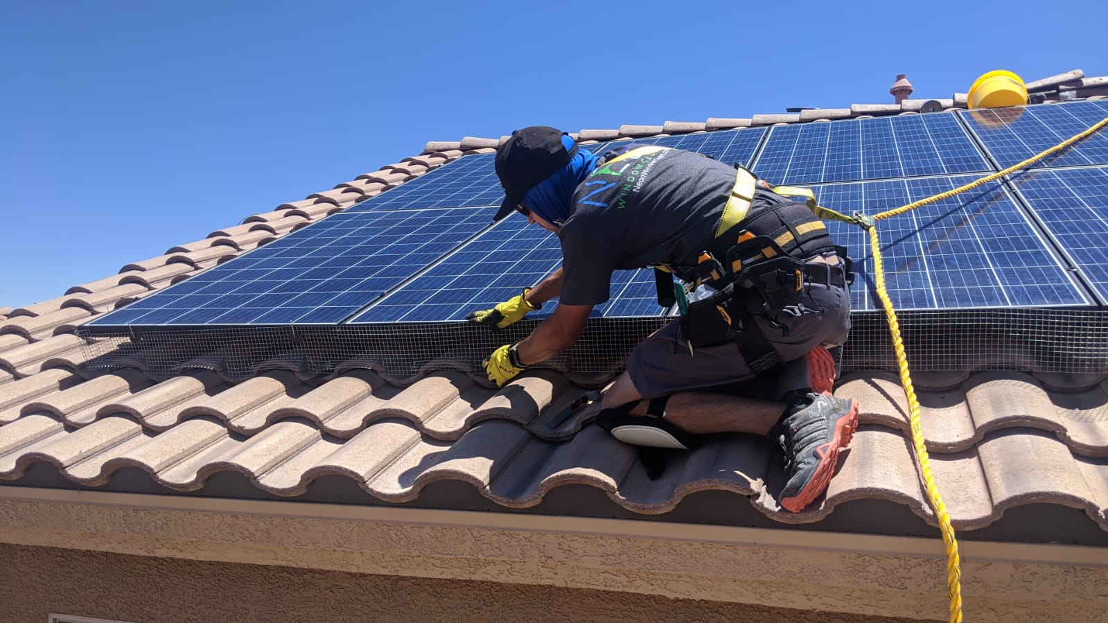 Pigeon proofing mesh being installed around solar panels on a North Las Vegas home