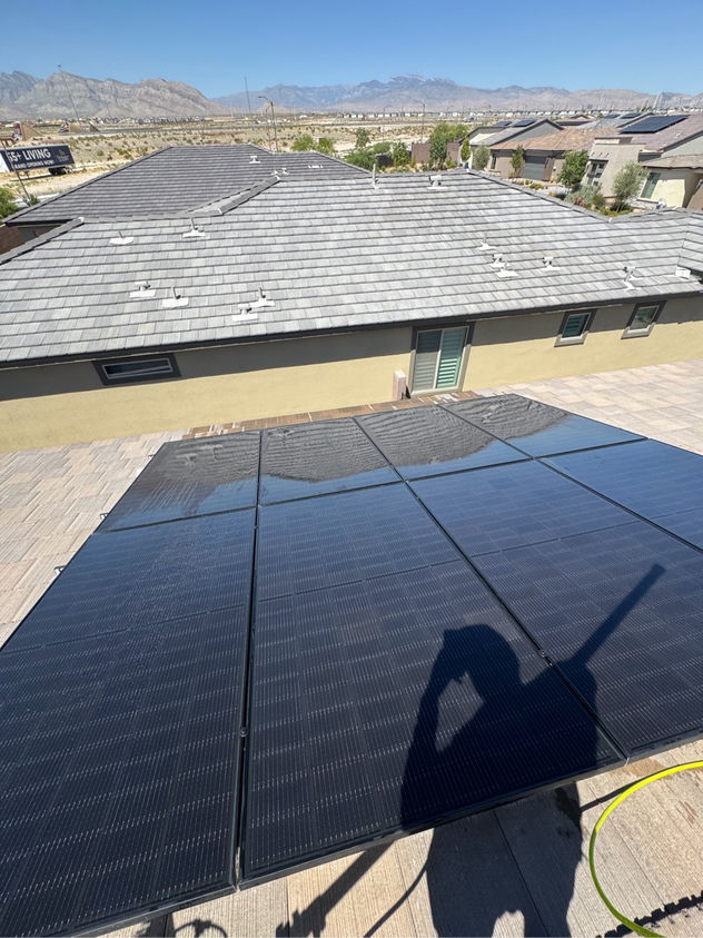 Solar panel cleaning in progress on a Las Vegas rooftop with Las Vegas valley and desert mountains visible in the background